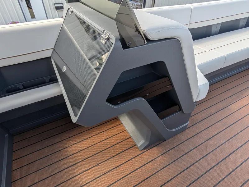 Slide: The Image of 2025 Manitou Explore boat interior with sleek seating and modern storage design. - 26