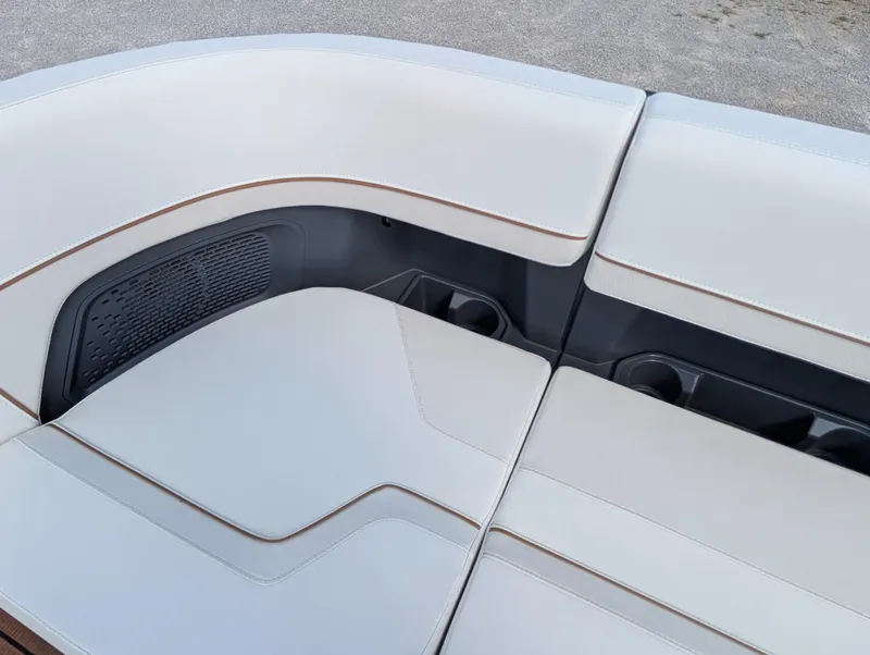 Slide: The Image of 2025 Manitou Explore boat seating with sleek white upholstery and integrated cup holders. - 28