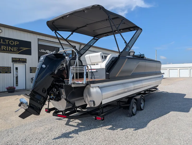 Slide: The Image of 2025 Manitou Explore pontoon boat on trailer at Hilltop Marine dealership. - 4