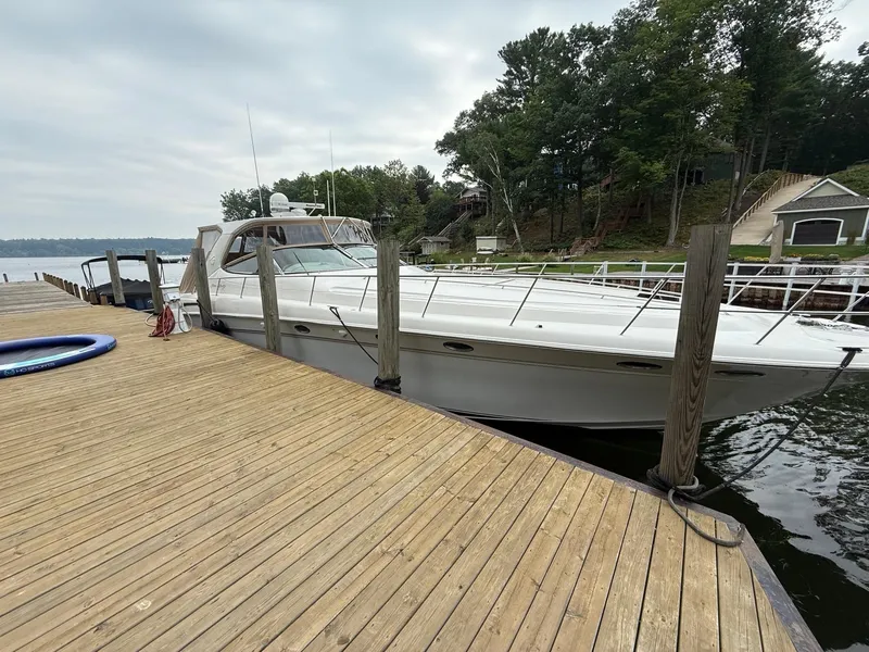 Slide: The Image of 1998 Sea Ray 540 Sundancer yacht docked by a wooden pier, surrounded by trees. - 11