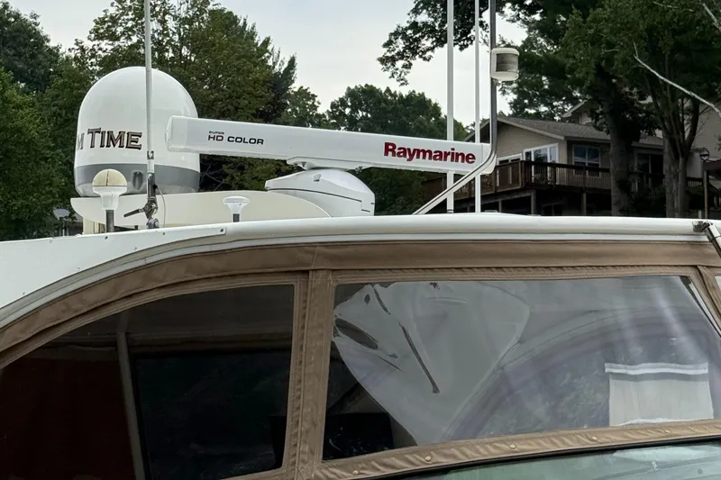 Slide: The Image of 1998 Sea Ray 540 Sundancer with Raymarine radar, docked near trees and houses. - 18