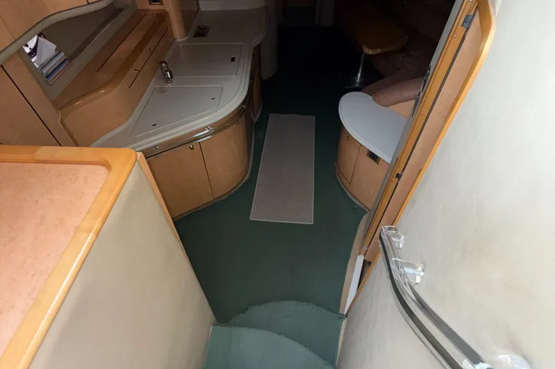 Slide: The Image of Interior of 1998 Sea Ray 540 Sundancer yacht, featuring a compact kitchen and seating area. - 26