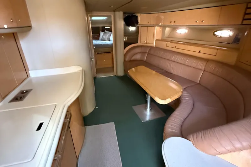 Slide: The Image of Luxurious interior of 1998 Sea Ray 540 Sundancer yacht with leather seating and wooden table. - 3
