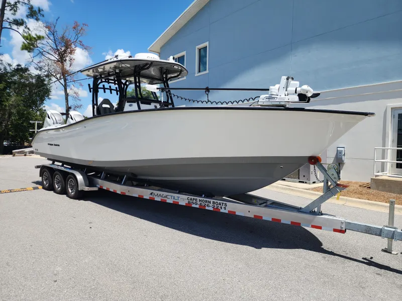 Slide: The Image of 2025 Cape Horn 32 XS boat on trailer, parked outdoors near a building. - 2