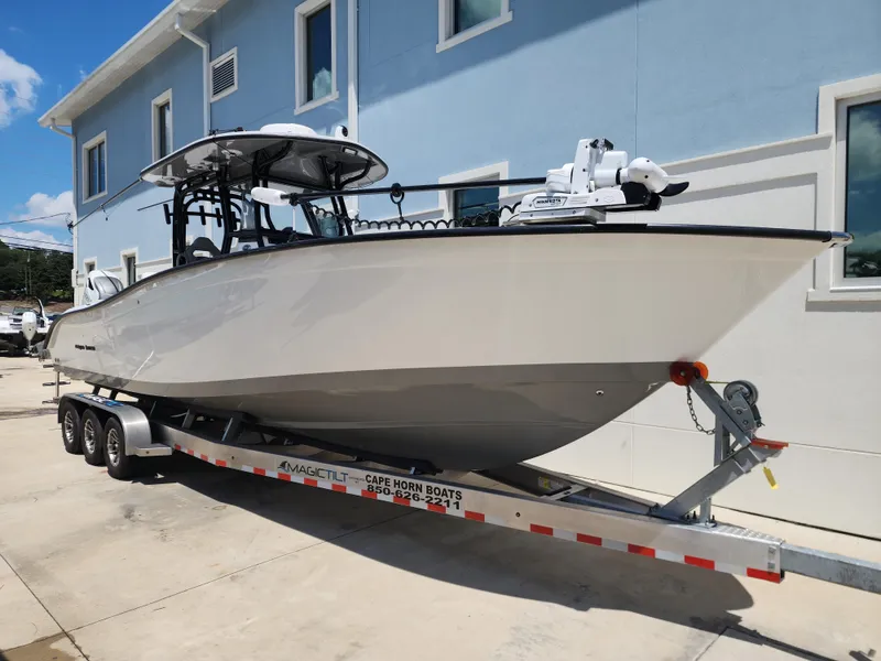 Slide: The Image of 2025 Cape Horn 32 XS boat on trailer, parked beside a blue building. - 4