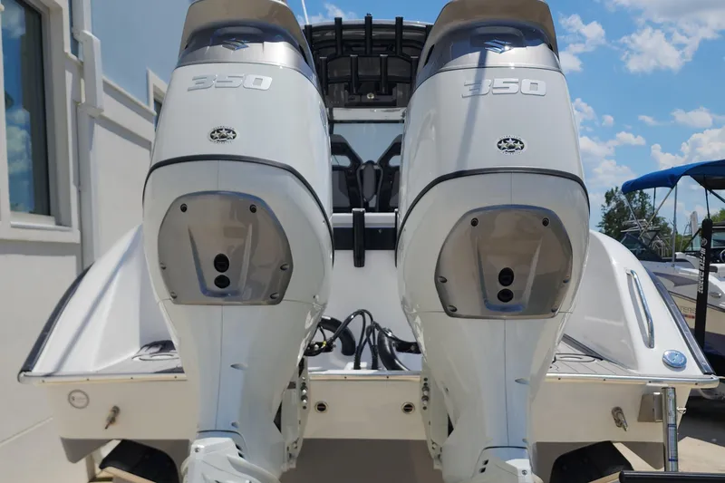Slide: The Image of 2025 Cape Horn 32 XS boat with dual 350 horsepower engines, docked under a clear sky. - 8