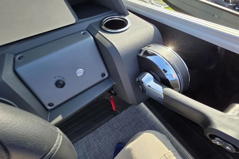 Slide: The Image of 2026 Sun Tracker Party Barge 20 DLX steering console with cup holder and controls. - 19