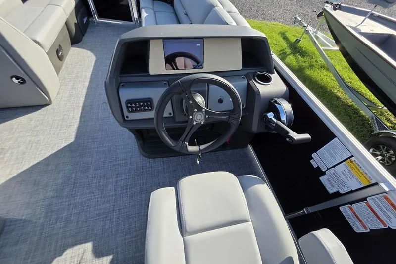 Slide: The Image of 2026 Sun Tracker Party Barge 20 DLX helm with steering wheel and control panel. - 20