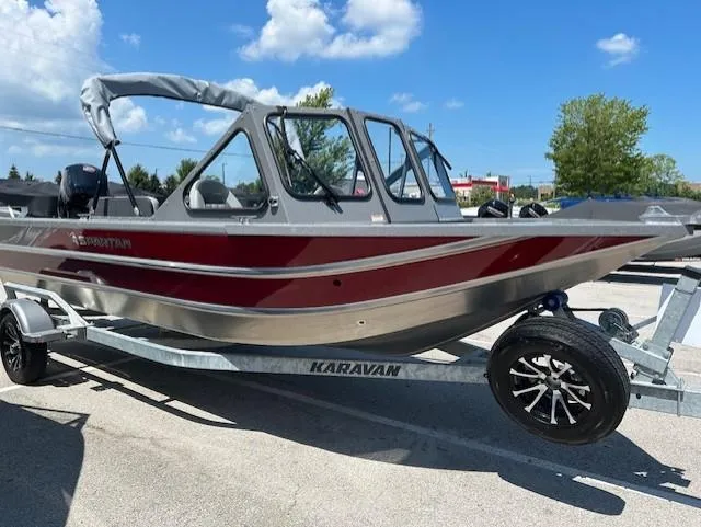 The Image of 2025 Spartan 20 Areus boat on Karavan trailer, parked outdoors under blue sky. - 1