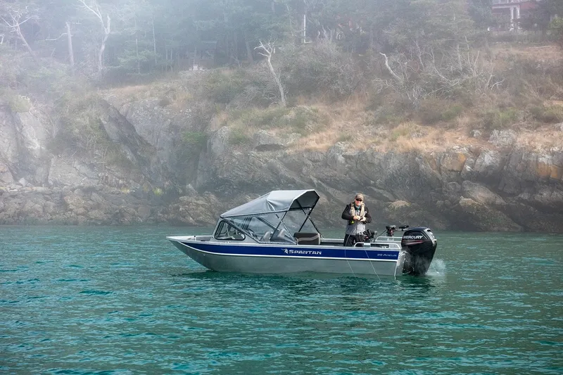 Slide: The Image of 2025 Spartan 20 Areus boat on misty water near rocky shoreline. - 11