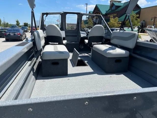 Slide: The Image of 2025 Spartan 20 Areus boat interior with seating, parked outdoors under clear sky. - 6