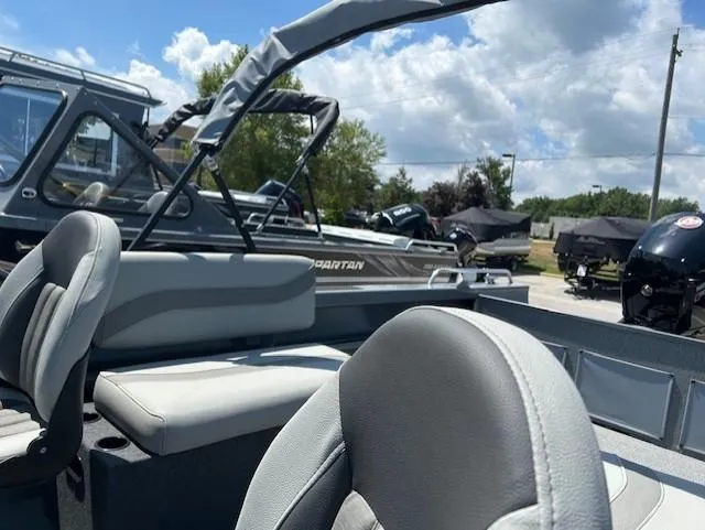 Slide: The Image of 2025 Spartan 20 Areus boat interior with seating, under a partly cloudy sky. - 7