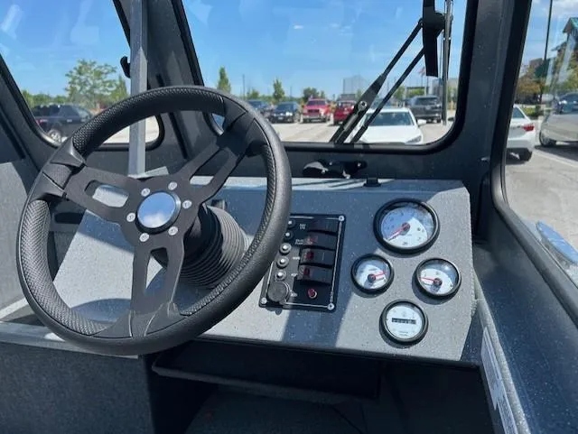 Slide: The Image of Steering wheel and dashboard of 2025 Spartan 20 Areus boat, featuring gauges and controls. - 9