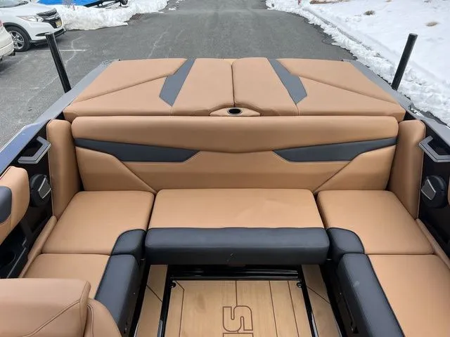 Slide: The Image of 2024 Axis Wake Research A20 boat interior with tan and black seating, parked on snowy pavement. - 10