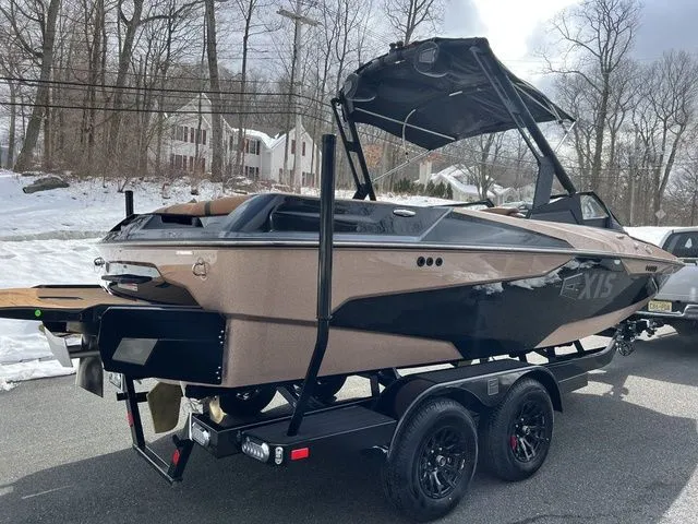 Slide: The Image of 2024 Axis Wake Research A20 boat on trailer, parked in snowy residential area. - 15