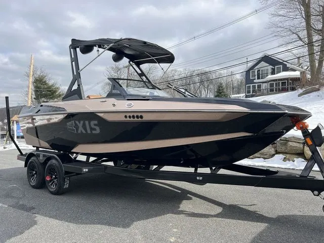 Slide: The Image of 2024 Axis Wake Research A20 boat on trailer, parked on snowy roadside. - 3