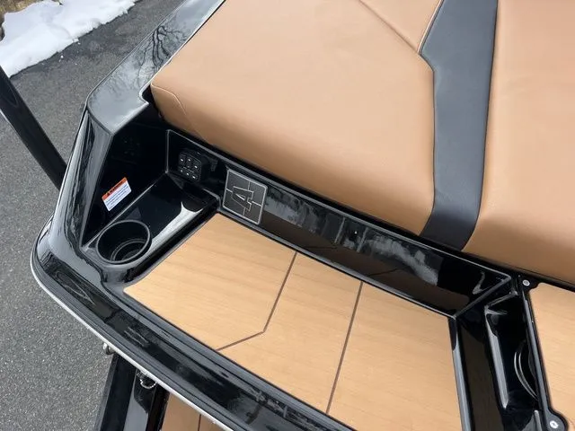 Slide: The Image of 2024 Axis Wake Research A20 boat interior with tan and black seating, cup holder, and control panel. - 4