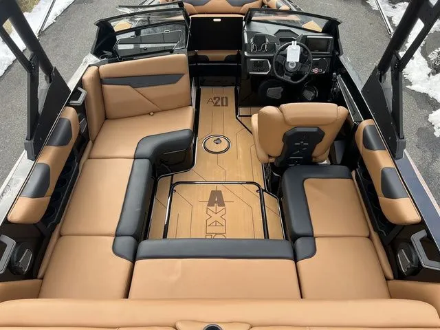 Slide: The Image of 2024 Axis Wake Research A20 boat interior with tan and black seating, modern dashboard, and spacious layout. - 6