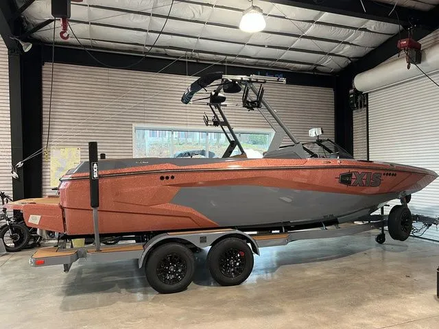 Slide: The Image of 2024 Axis Wake Research A225 boat in a showroom, featuring a sleek design and vibrant color. - 11