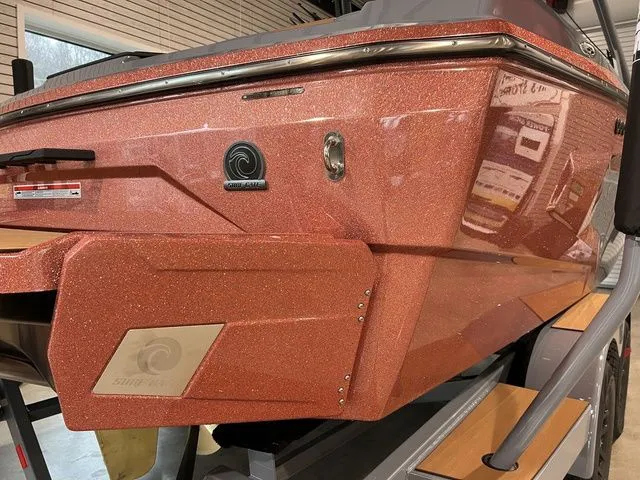 Slide: The Image of 2024 Axis Wake Research A225 boat with a sparkling orange finish in a showroom. - 14