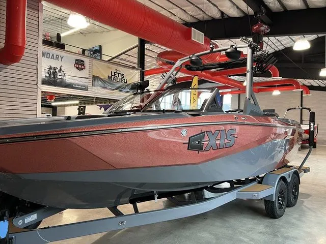 Slide: The Image of 2024 Axis Wake Research A225 boat displayed indoors, featuring sleek design and vibrant colors. - 17