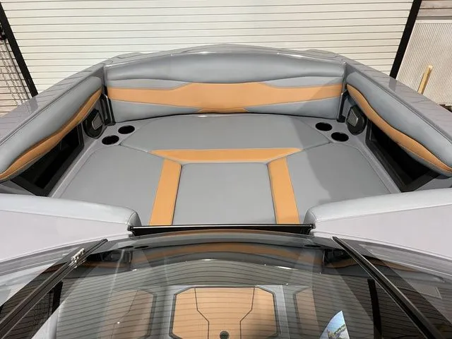 Slide: The Image of 2024 Axis Wake Research A225 boat interior with gray and tan seating, cup holders visible. - 18