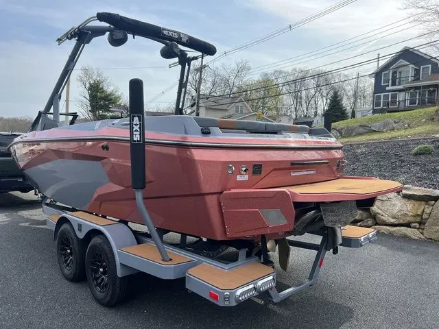 Slide: The Image of 2024 Axis Wake Research A225 boat on trailer, parked outdoors. - 3