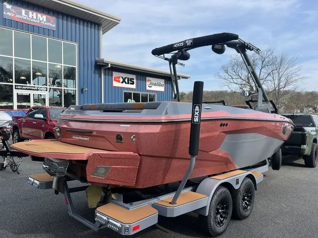 Slide: The Image of 2024 Axis Wake Research A225 boat on trailer outside dealership. - 4