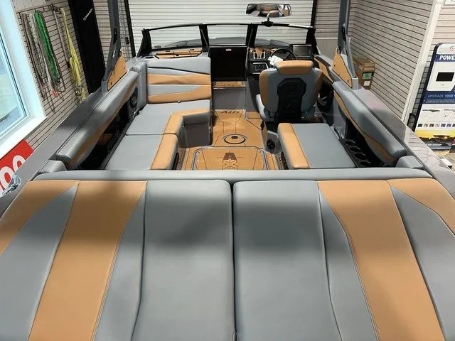 Slide: The Image of 2024 Axis Wake Research A225 boat interior with gray and tan upholstery, spacious seating, and modern design. - 6