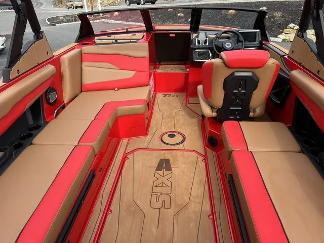 Slide: The Image of 2024 Axis Wake Research T235 boat interior with red and tan seating, modern dashboard. - 10
