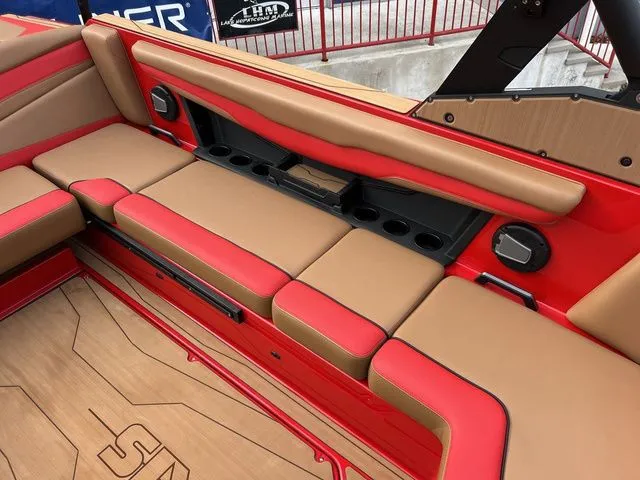 Slide: The Image of 2024 Axis Wake Research T235 boat interior with red and tan seating, cup holders, and sleek design. - 8