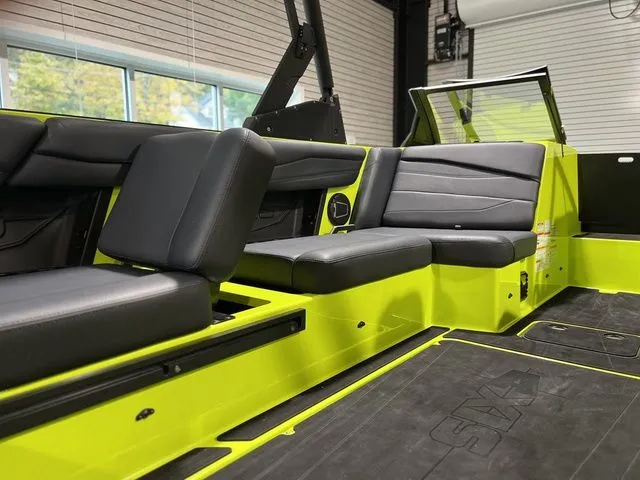 Slide: The Image of 2024 Axis Wake Research A245 boat interior with black seating and vibrant yellow accents. - 5