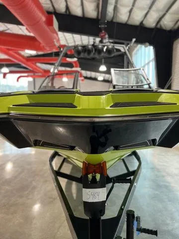 Slide: The Image of 2024 Axis Wake Research A245 boat in showroom, vibrant green and black design. - 6