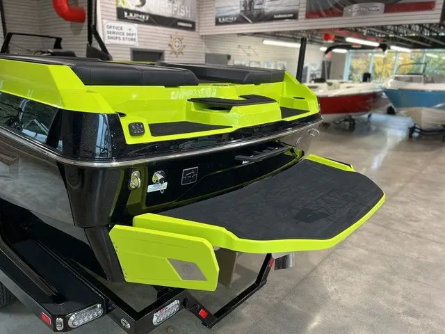 Slide: The Image of 2024 Axis Wake Research A245 boat with vibrant green detailing in a showroom. - 8