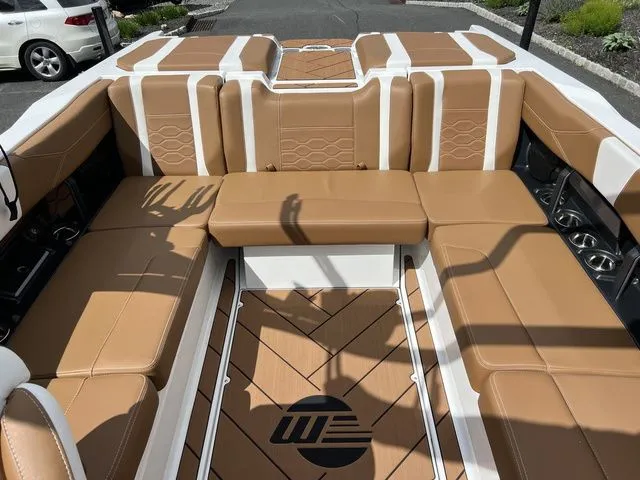 Slide: The Image of 2024 Malibu 23 LSV boat interior with tan and white seating, luxury design. - 7