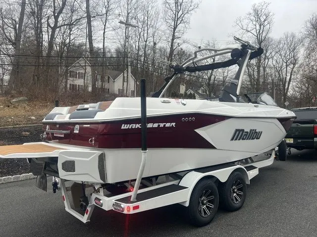 Slide: The Image of 2024 Malibu 23 LSV boat on trailer, parked outdoors, showcasing sleek design and modern features. - 3