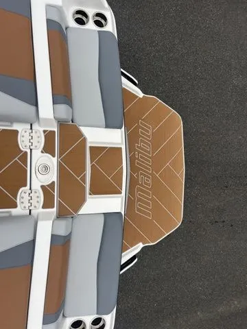 Slide: The Image of 2024 Malibu 23 LSV boat interior with brown and gray seating, top view. - 9