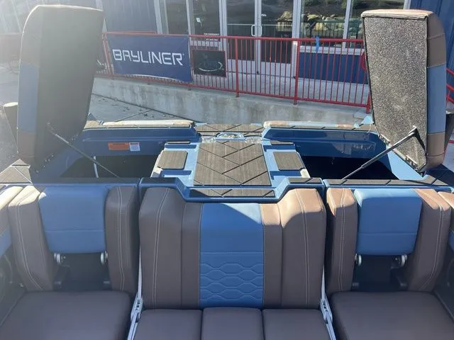 Slide: The Image of 2024 Malibu 23 LSV boat interior with blue and brown seating, open storage compartments. - 12