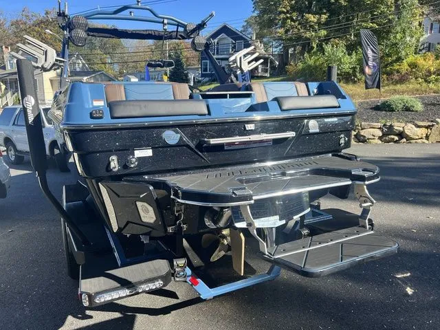 Slide: The Image of 2024 Malibu 23 LSV boat with sleek design and advanced features, parked outdoors. - 4