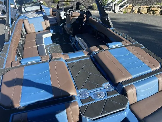 Slide: The Image of 2024 Malibu 23 LSV boat interior with blue and brown seating, showcasing luxury design. - 6