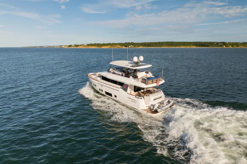 Slide: The Image of 2019 Sirena 64 yacht cruising on open water under a clear sky. - 12
