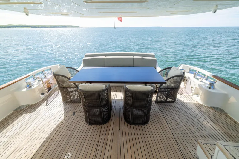 Slide: The Image of Luxurious Sirena 64 yacht deck with dining area, overlooking serene ocean waters, 2019 model. - 14