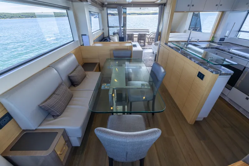 Slide: The Image of Luxurious interior of 2019 Sirena 64 yacht with modern dining area and scenic ocean view. - 24