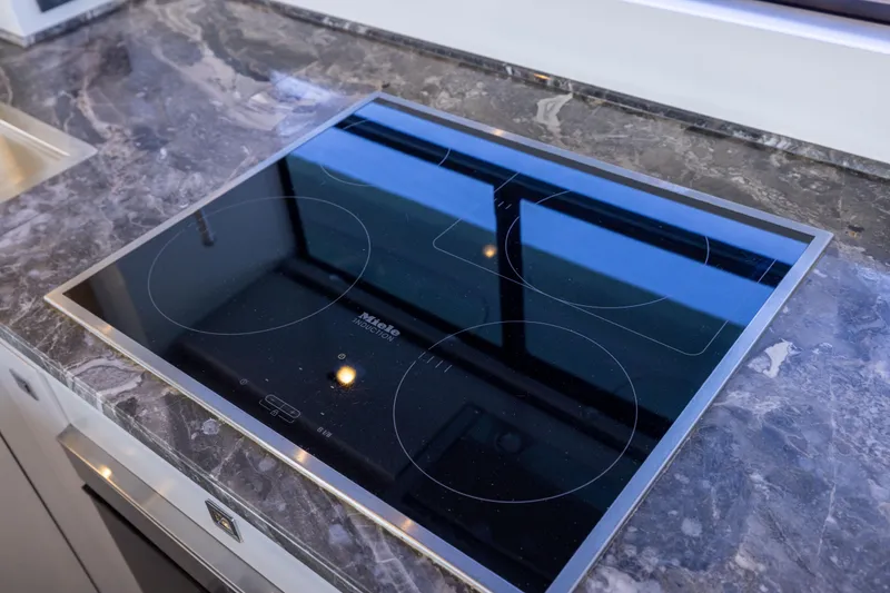 Slide: The Image of Modern induction cooktop on marble countertop in 2019 Sirena 64 yacht kitchen. - 31