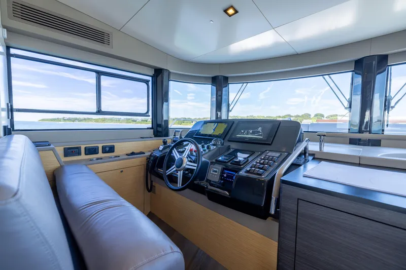 Slide: The Image of Luxurious helm of 2019 Sirena 64 yacht with panoramic windows and modern controls. - 35