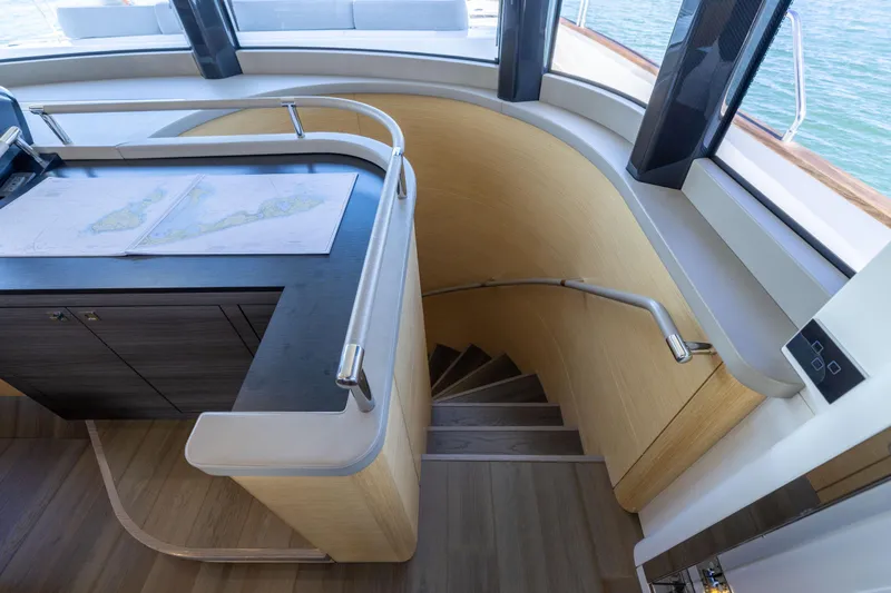 Slide: The Image of Interior of 2019 Sirena 64 yacht with navigation desk and curved staircase. - 46