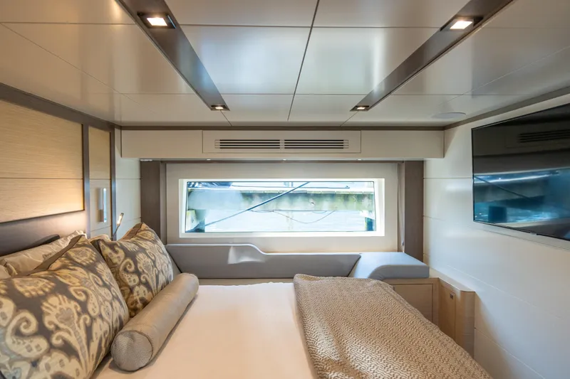 Slide: The Image of Luxurious interior of 2019 Sirena 64 yacht with elegant bedding and large window view. - 63