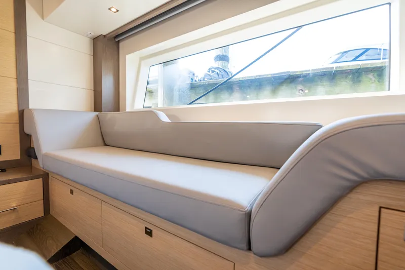 Slide: The Image of Luxurious interior of 2019 Sirena 64 yacht with elegant seating and large window. - 64