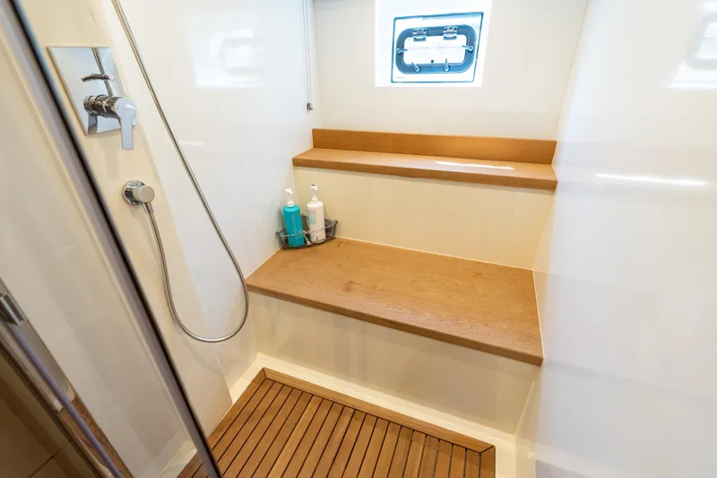 Slide: The Image of Shower area in 2019 Sirena 64 yacht with wooden bench and modern fixtures. - 70