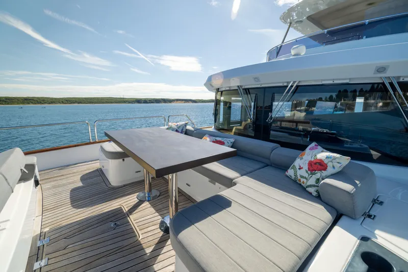 Slide: The Image of Luxurious 2019 Sirena 64 yacht deck with seating, table, and scenic ocean view. - 77